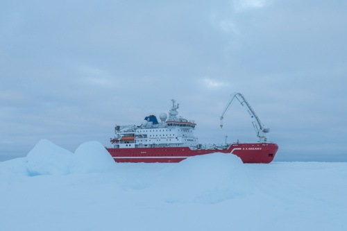 Image of ship in the distance with a background of ice by Esther Horvath / Falklands Maritime Heritage Trust.
